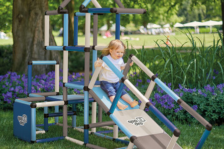 Girl sliding down ramp from climbing frame